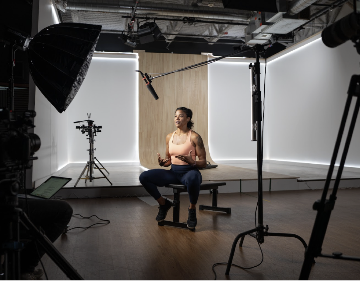 Elisabeth, seated, being interviewed during a behind-the-scenes Lyquid studio shoot